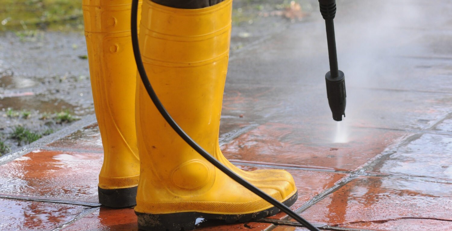 A person pressure washing a driveway - best small business ideas