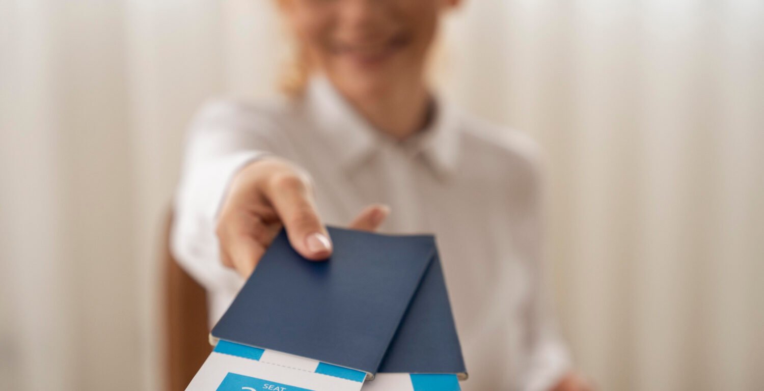 A female travel agent handing over two blue passports.